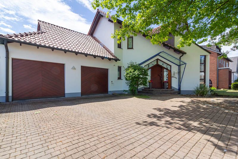 Großzügige Einfahrt, zwei Garagen und ein einladender Hauseingang – dieses Zuhause überzeugt schon beim ersten Eindruck.